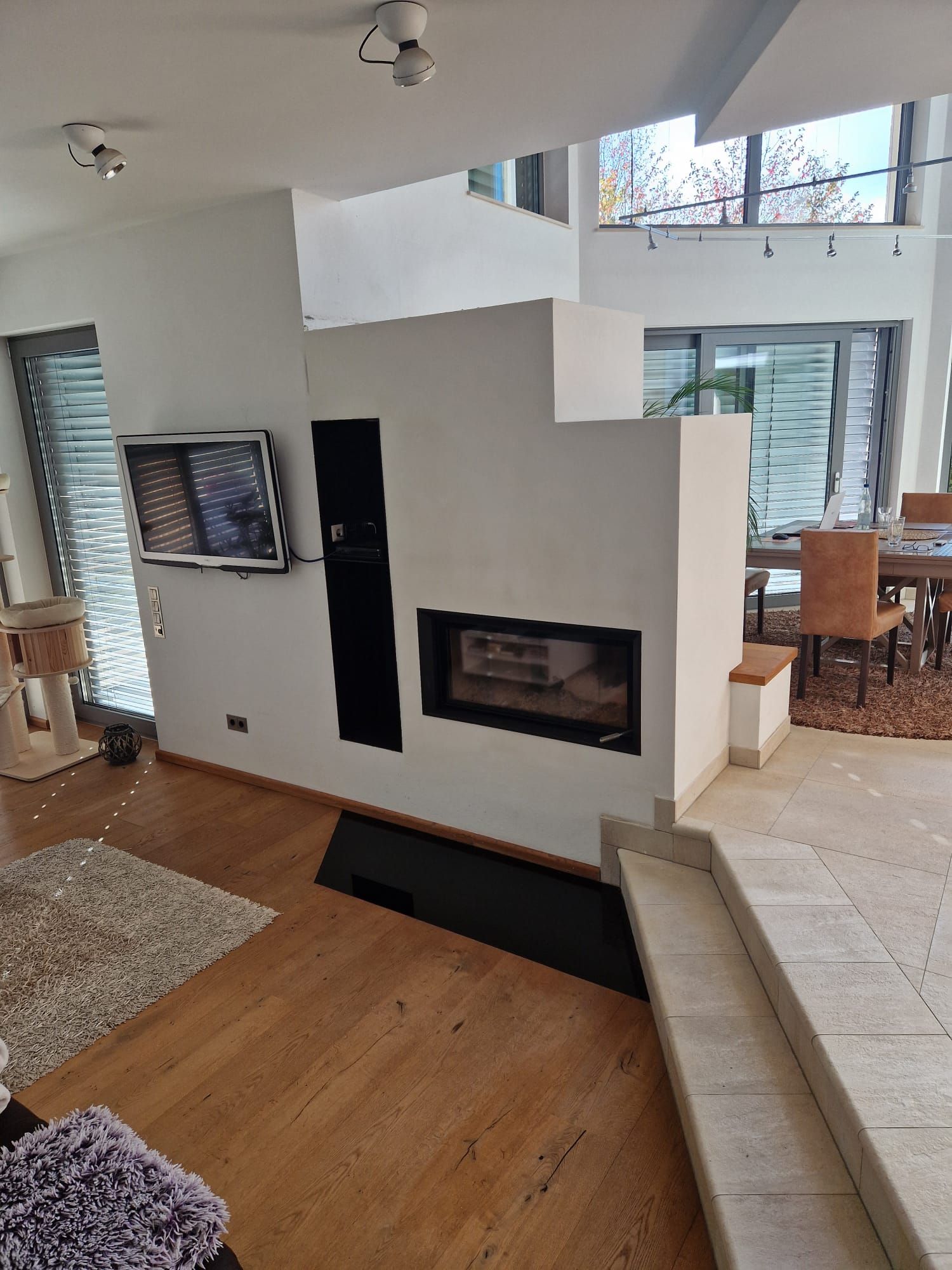 Kaminwand mit Panoramascheibe, in offener Architektur