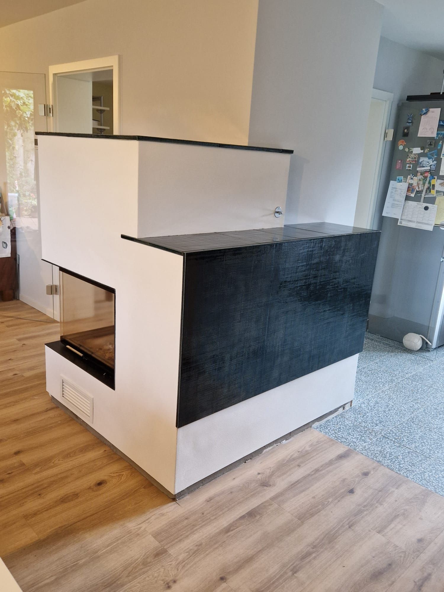 Kachelofen mit schwarzen Kacheln, mit Sichtfenster